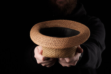 a hat stretched out of the dark for begging money