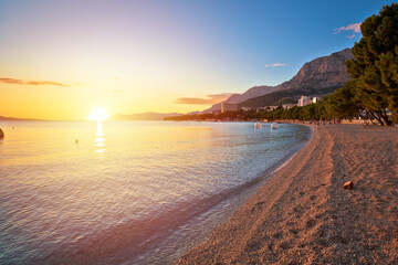 Makarska pebble beach and Biokovo mountain sunset view