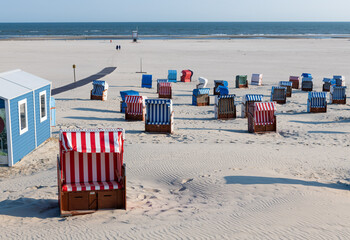 Path to white beach with colorful beach chairs on the Frisian island of Juist.