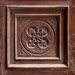 old ornate relief with flourishes on a wooden square board with frames and decoration - retro background surface	
