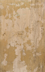 light yellow wall with peeling paint and chipped - rough vertical texture for a damaged background of a steampunk wallpaper