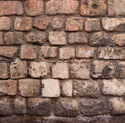 brickstones of and ancient wall of a medieval castle or a fortress - surface of big stone bricks for a texture background	