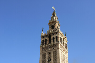 Fototapeta na wymiar the top of Giralda tower in Seville isolated with a clean blue sky in the background for a wallpaper
