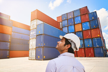 business foreman looking at the sky light in cargo container site for logistics service