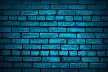 Blue grunge background. Lighting effect on an old painted brick wall. Blue brick wall with cracked...