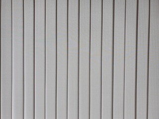 Obraz premium The surface of the gray or silver curtains has a modern linear pattern (vertical line). Which is an abstract background. Luxury gray curtain folded or wrapped. 