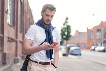 handsome hipster modern man using smart phone in the city