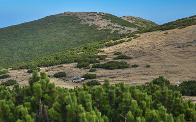 Off road car driving through Cindrel National Park. Autumn.