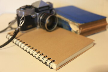 A close up of a brown notebook on the table Vintage camera in the background selective focus and shallow depth of field