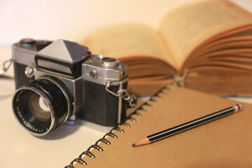 A close up of a brown notebook on the table Vintage camera in the background selective focus and shallow depth of field