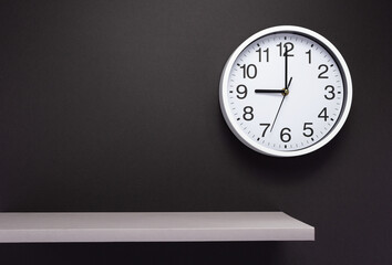 clock and shelf at wall background