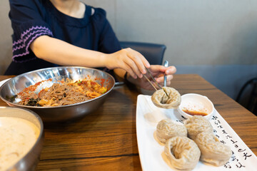 Woman eating steamed dumpling at restaurant
