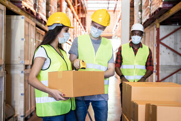 Group of worker wear safety helmet and mask working in warehouse.