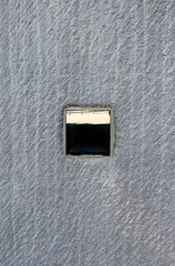 Abstract background of rough gray wall with reflective mirror box. Construction textures and pattern. Architectural design.