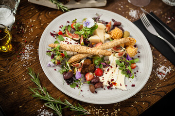Cheese platter for two: Goat cheese cream, gorgonzola, camembert, grissini and fig jam. Delicious healthy Italian traditional food closeup served for lunch in modern gourmet cuisine restaurant