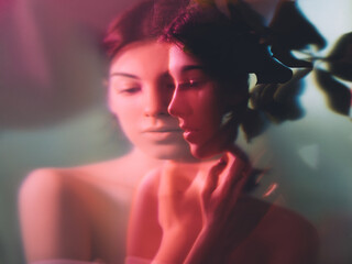 Art portrait. Feminine beauty. Sensual woman face blur silhouette in floral pattern neon red light...