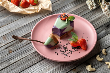 Blueberry cake, lemon, mint. Vegan, lactose free and sugar free. Laid on a pink plate, а small piece is broken off and the structure of the cake is visible.