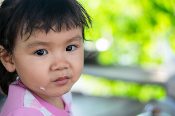 A little girl with a smiling face, three years old, ASEAN people are eating.