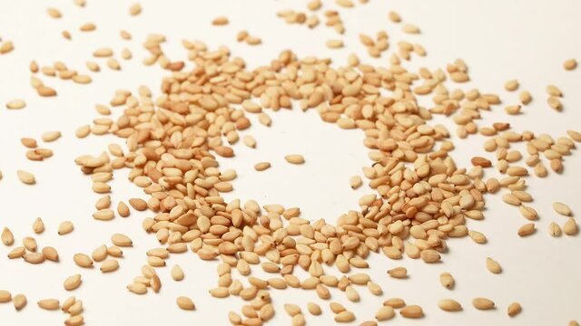 Making a heap of white sesame seed close up