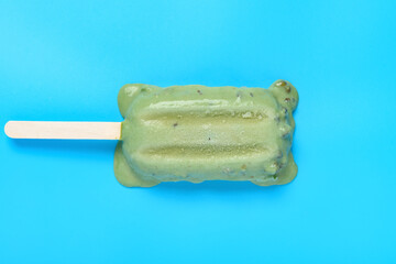 top view mung bean popsicle starts melting on a blue background