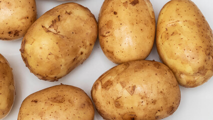 A slide of fresh young potatoes on the white background. The new harvest. Raw potatoes. Agriculture concept.