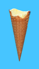 side view vanilla flaovr ice cream cone with couple of bites on a blue background
