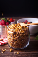 Healthy oat granola muesli cereals in a jar with fresh berries on the background