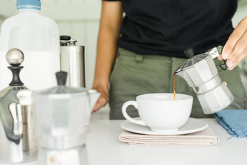 The professional of a barista poured coffee. making hot coffee with equipment, tool brewing on bar at kitchen home