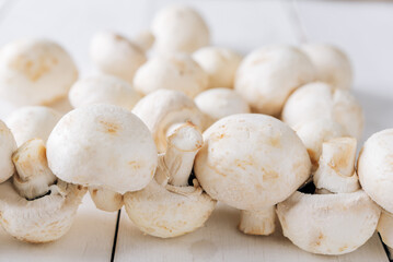 Several mushrooms on a white wooden background