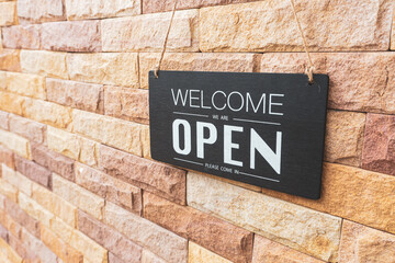 Fototapeta premium Come in we're open, vintage black retro sign in brick wall