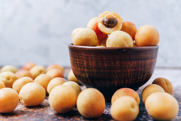 Lots of ripe yellow apricots close up in a crockery on the table