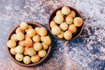 Lots of ripe yellow apricots close up in a crockery on the table
