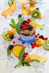 thirst quenching glass with cold water and fresh summer fruit with ice