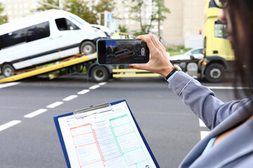 An insurance agent takes photo of crashed car after an accident on smartphone. Car insurance concept