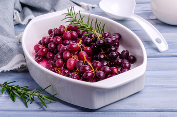 Baked bunches of dark grapes with rosemary