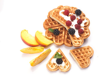 Waffles with berries and peaches isolated on white background
