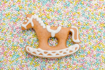 Lebkuchenpferd mit Zuckerguss und vielen bunten Liebesperlen als Hintergrund