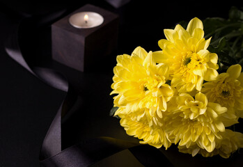 Grief and loss concept. Funeral yellow asters on a black background