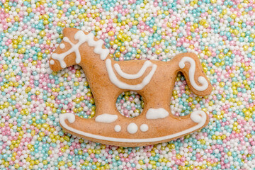 Lebkuchenpferd mit Zuckerguss und vielen bunten Liebesperlen als Hintergrund