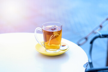 Tea on white table sea port background ,warm tone. Tea bags in glass on a restaurant in the port near the sea lit by the setting sun. Concept of vacation, relaxation, calm, lifestyle.