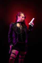Young woman wearing a studded leather jacket, holding a revolver on her forehead	
