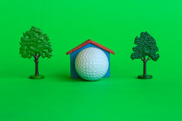 a house by a golf ball surrounded by trees and greenery /a house with a golf ball surrounded by trees and greenery , is the symbol of the presence of a golf -club