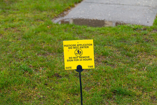 Yellow Pesticide Application Sign On Resedential Front Lawn