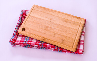Bamboo cutting board on a fabric. It is a wood cutting board isolated on white background.