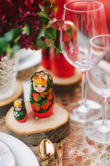 Wooden toy - matryoshka. Table setting in  national Russian style. Red in decor and decoration.