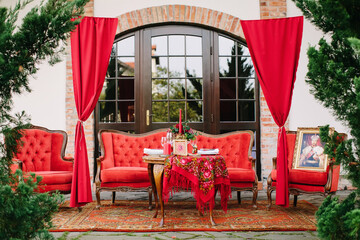 Festive table setting in national Russian style. Red color in decor and decoration of event.