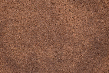 Dry coffee sediment, texture of ground bean, cracks on the surface.