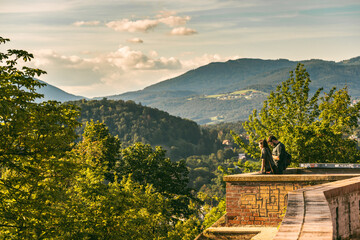 Couple at Schlossberg hill in Graz enjoying the view at mountains