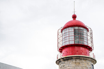 red Lighthouse tower in a white sky.