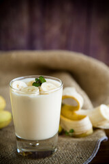 tasty homemade yogurt with bananas in a glass on a wooden table